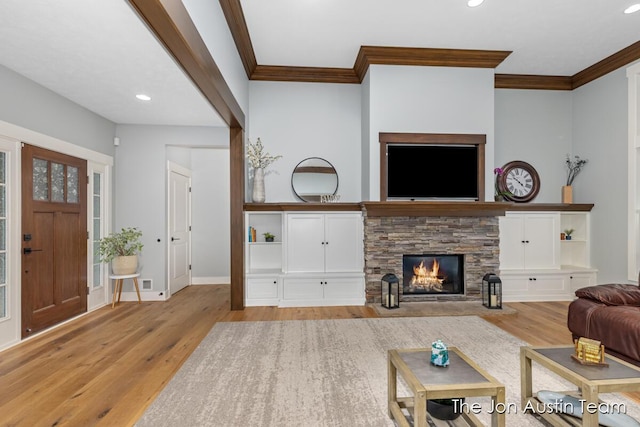 7979 Ella Terrace Dr, Rockford, MI 49341 - living room with wood finished floors, crown molding, recessed lighting, and a stone fireplace