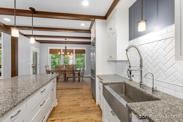 7979 Ella Terrace Dr, Rockford, MI 49341 - kitchen with a chandelier, white cabinets, high end fridge, light wood-type flooring, and tasteful backsplash