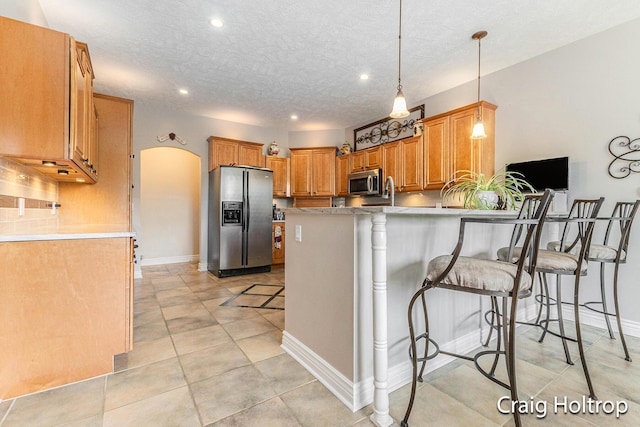 3566 Little Timber Ct SW, Grand Rapids, MI 49534 - kitchen with appliances with stainless steel finishes, a peninsula, recessed lighting, arched walkways, and a textured ceiling