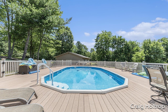 3566 Little Timber Ct SW, Grand Rapids, MI 49534 - view of swimming pool with a wooden deck and view of wooded area
