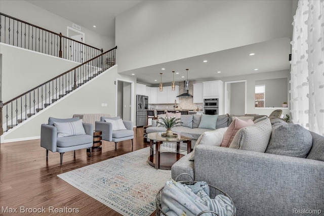 1043 Kendall Ct, Lake Orion, MI 48360 - living area with dark wood-style flooring, stairs, recessed lighting, and a high ceiling