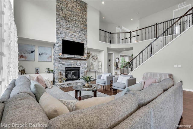 1043 Kendall Ct, Lake Orion, MI 48360 - living area with wood finished floors, a towering ceiling, a stone fireplace, stairway, and recessed lighting