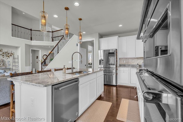 1043 Kendall Ct, Lake Orion, MI 48360 - kitchen with appliances with stainless steel finishes, recessed lighting, a kitchen island with sink, white cabinets, and decorative backsplash