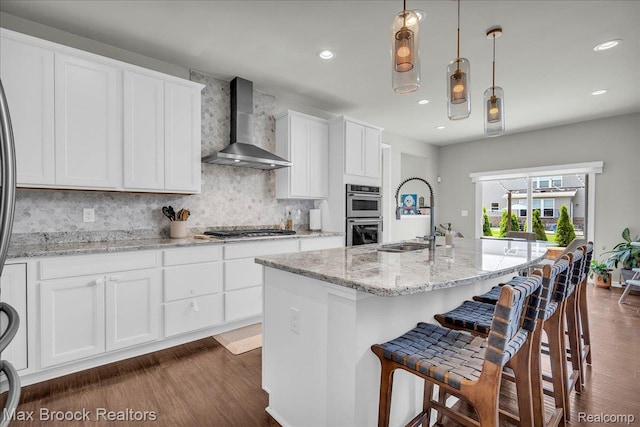 1043 Kendall Ct, Lake Orion, MI 48360 - kitchen featuring wall chimney exhaust hood, appliances with stainless steel finishes, dark wood finished floors, white cabinets, and recessed lighting
