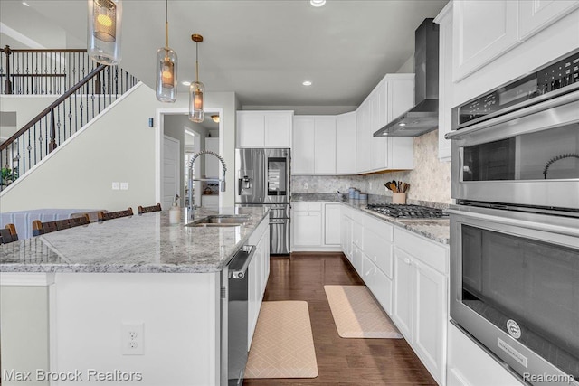 1043 Kendall Ct, Lake Orion, MI 48360 - kitchen with wall chimney range hood, stainless steel appliances, dark wood finished floors, decorative backsplash, and white cabinetry