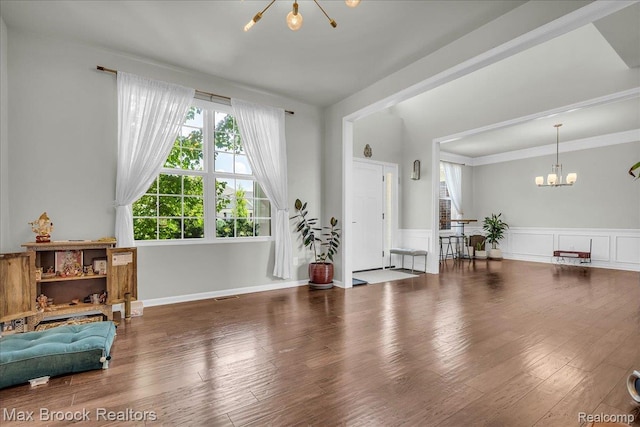 1043 Kendall Ct, Lake Orion, MI 48360 - entryway featuring a chandelier, wainscoting, wood finished floors, and ornamental molding