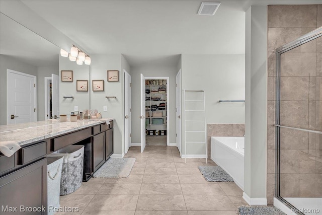 1043 Kendall Ct, Lake Orion, MI 48360 - full bath with a walk in closet, vanity, a stall shower, a garden tub, and tile patterned floors