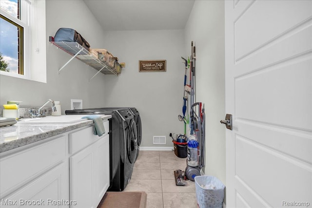 1043 Kendall Ct, Lake Orion, MI 48360 - laundry room featuring washer and clothes dryer, light tile patterned floors, and cabinet space