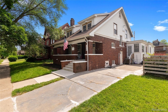 1725 Seyburn St, Detroit, MI 48214 - view of front of property with brick siding, entry steps, a front yard, a chimney, and covered porch