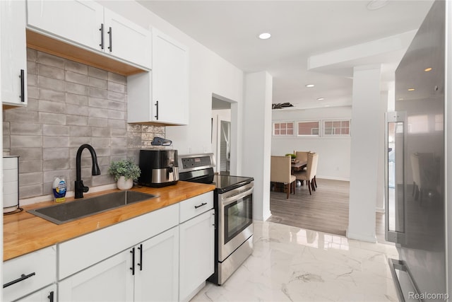 1725 Seyburn St, Detroit, MI 48214 - kitchen with stainless steel range with electric cooktop, wooden counters, tasteful backsplash, recessed lighting, and white cabinets