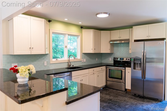 3580 Hazelton Ave, Rochester Hills, MI 48307 - kitchen featuring appliances with stainless steel finishes, a peninsula, dark stone countertops, under cabinet range hood, and backsplash