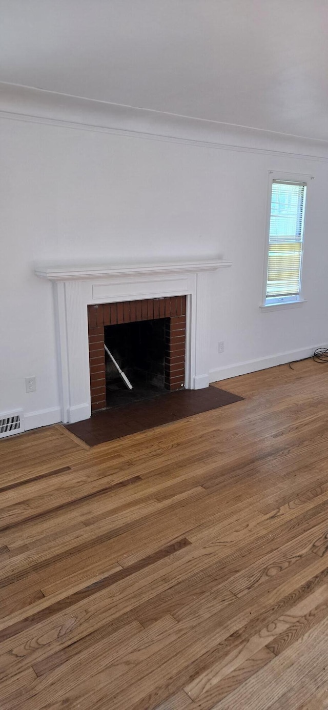 15744 Ferguson St, Detroit, MI 48227 - detailed view of a fireplace, wood finished floors, and crown molding