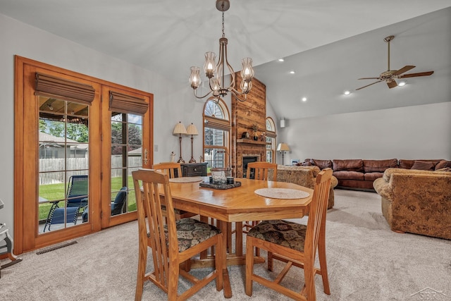 1381 Briarson Dr, Saginaw, MI 48638 - dining room featuring light colored carpet, vaulted ceiling, a chandelier, ceiling fan, and a stone fireplace