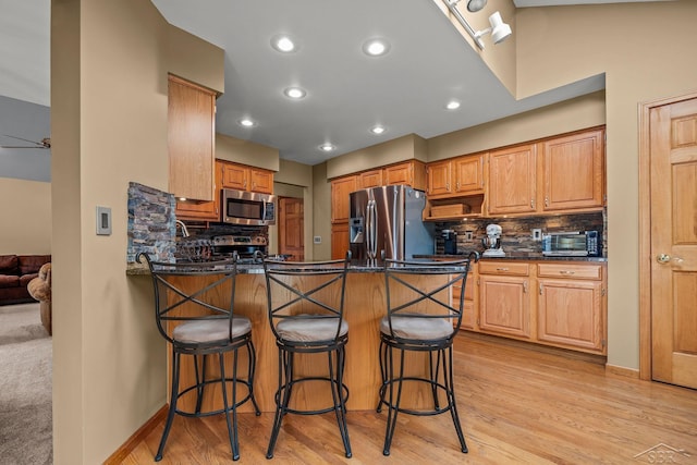 1381 Briarson Dr, Saginaw, MI 48638 - kitchen with stainless steel appliances, a peninsula, decorative backsplash, light wood-type flooring, and recessed lighting