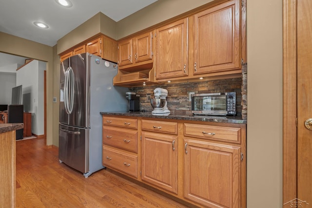1381 Briarson Dr, Saginaw, MI 48638 - kitchen with stainless steel fridge with ice dispenser, light wood-style flooring, tasteful backsplash, brown cabinets, and recessed lighting