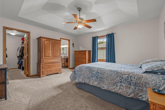1381 Briarson Dr, Saginaw, MI 48638 - bedroom featuring light colored carpet, a walk in closet, a tray ceiling, a closet, and a ceiling fan
