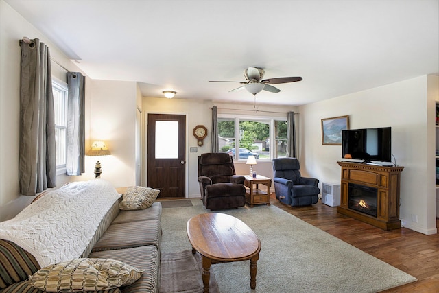 5468 Wellesley Dr, Jackson, MI 49201 - living area featuring wood finished floors, a glass covered fireplace, and ceiling fan