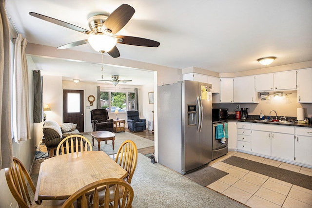 5468 Wellesley Dr, Jackson, MI 49201 - kitchen with appliances with stainless steel finishes, ceiling fan, dark countertops, light tile patterned floors, and open floor plan