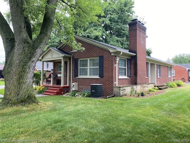 41079 E Ann Arbor Trl, Plymouth, MI 48170 - view of front facade featuring brick siding, a chimney, a front yard, and a porch