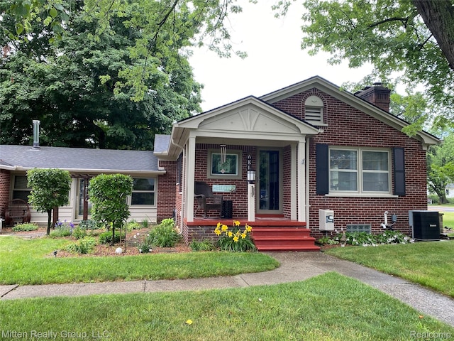 41079 E Ann Arbor Trl, Plymouth, MI 48170 - view of front facade featuring brick siding, a chimney, a front yard, and covered porch