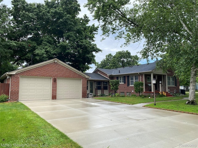 41079 E Ann Arbor Trl, Plymouth, MI 48170 - ranch-style home with brick siding, a garage, driveway, and a front lawn