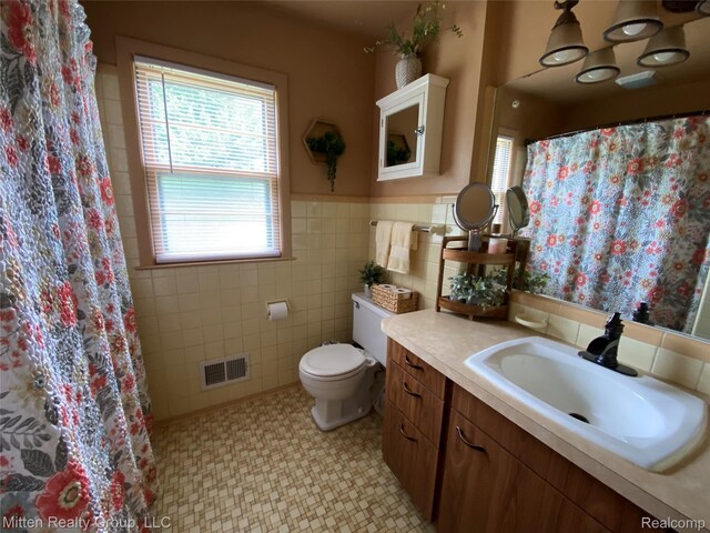 41079 E Ann Arbor Trl, Plymouth, MI 48170 - full bathroom featuring tile walls, plenty of natural light, vanity, wainscoting, and a shower with shower curtain