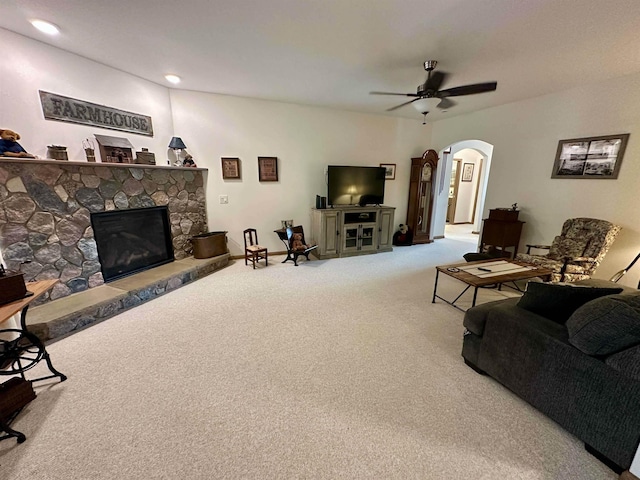 308 W Hosmer St, Saint Charles, MI 48655 - living area with carpet floors, a stone fireplace, arched walkways, and a ceiling fan