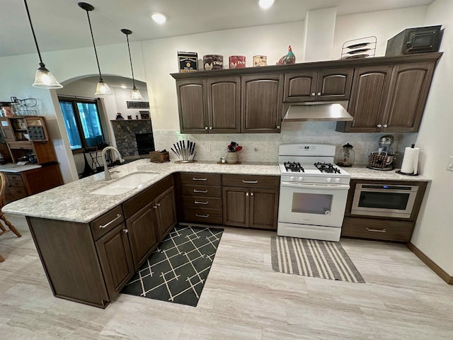 308 W Hosmer St, Saint Charles, MI 48655 - kitchen featuring white range with gas stovetop, exhaust hood, dark brown cabinets, and a peninsula