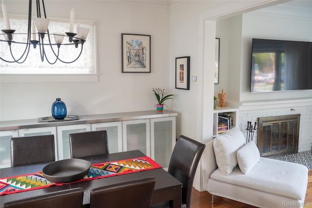 1036 Irving Ave, Royal Oak, MI 48067 - dining room with a chandelier, a brick fireplace, wood finished floors, and crown molding