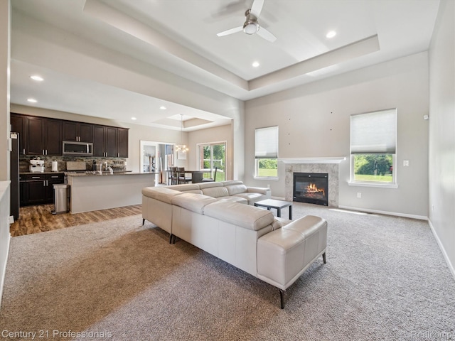 2655 Devondale Rd, Rochester Hills, MI 48309 - carpeted living area with a tray ceiling, a ceiling fan, recessed lighting, and a high end fireplace
