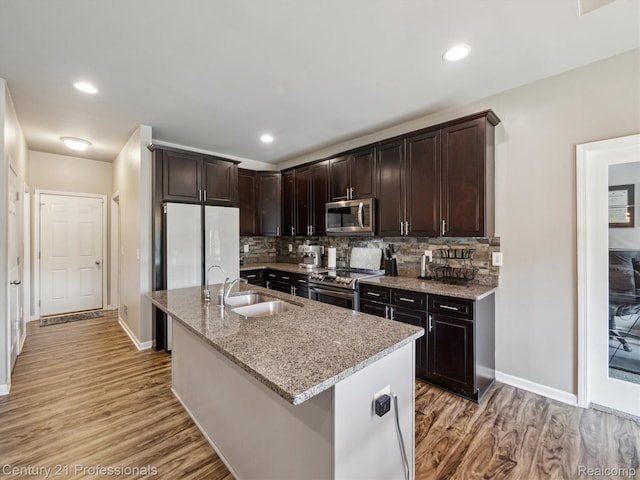2655 Devondale Rd, Rochester Hills, MI 48309 - kitchen featuring appliances with stainless steel finishes, light stone counters, light wood-style floors, decorative backsplash, and recessed lighting