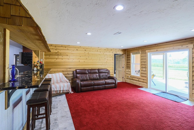 9434 84th St SE, Alto, MI 49302 - carpeted living area featuring recessed lighting, wooden walls, and a textured ceiling