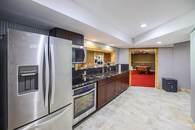 9434 84th St SE, Alto, MI 49302 - kitchen featuring stainless steel appliances, dark stone countertops, recessed lighting, tasteful backsplash, and dark brown cabinets
