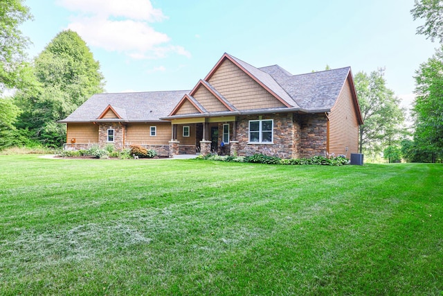 9434 84th St SE, Alto, MI 49302 - view of front of property with stone siding, a front yard, covered porch, and roof with shingles