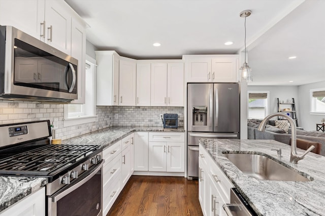 711 N Alexander Ave, Royal Oak, MI 48067 - kitchen featuring stainless steel appliances, white cabinets, dark wood finished floors, backsplash, and decorative light fixtures