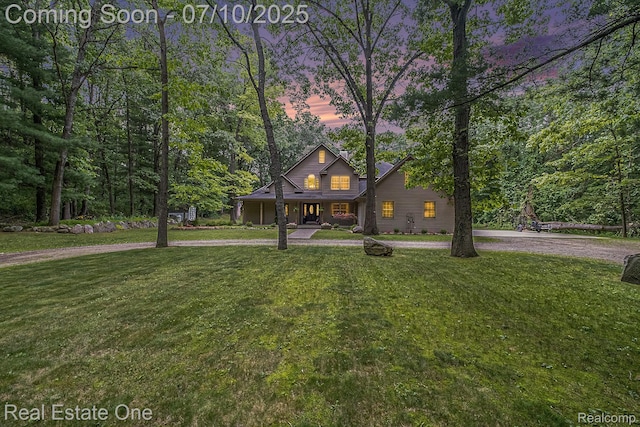 359 High Bluffs Dr, Ortonville, MI 48462 - view of front facade featuring a yard, curved driveway, and covered porch