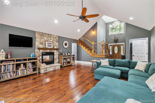 359 High Bluffs Dr, Ortonville, MI 48462 - living room with high vaulted ceiling, stairway, ceiling fan, a stone fireplace, and wood finished floors