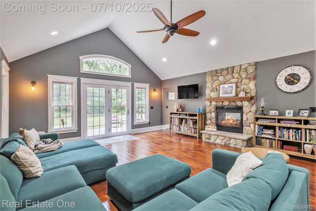 359 High Bluffs Dr, Ortonville, MI 48462 - living room with ceiling fan, a stone fireplace, high vaulted ceiling, french doors, and wood finished floors
