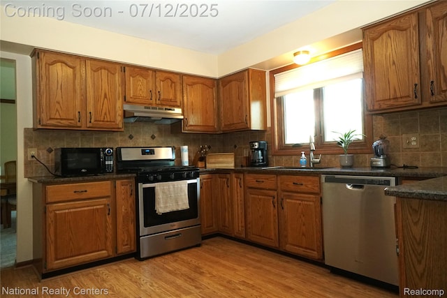19230 Augusta Ct, Livonia, MI 48152 - kitchen featuring stainless steel appliances, under cabinet range hood, brown cabinets, and backsplash