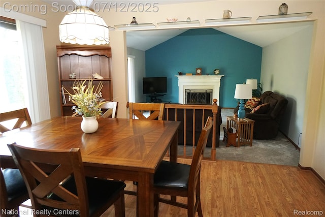 19230 Augusta Ct, Livonia, MI 48152 - dining space featuring wood finished floors, a glass covered fireplace, and lofted ceiling
