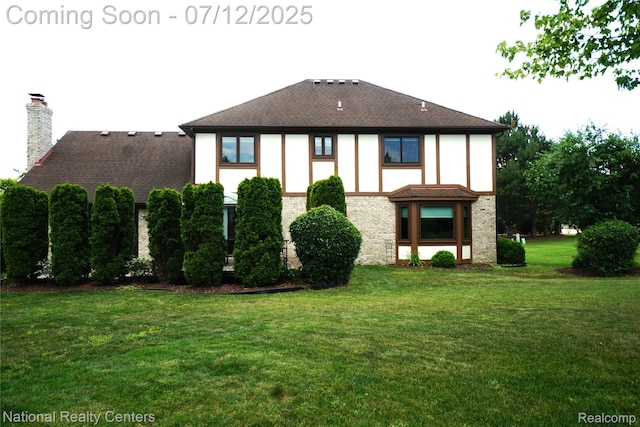 19230 Augusta Ct, Livonia, MI 48152 - back of house featuring a chimney, a lawn, brick siding, and a shingled roof
