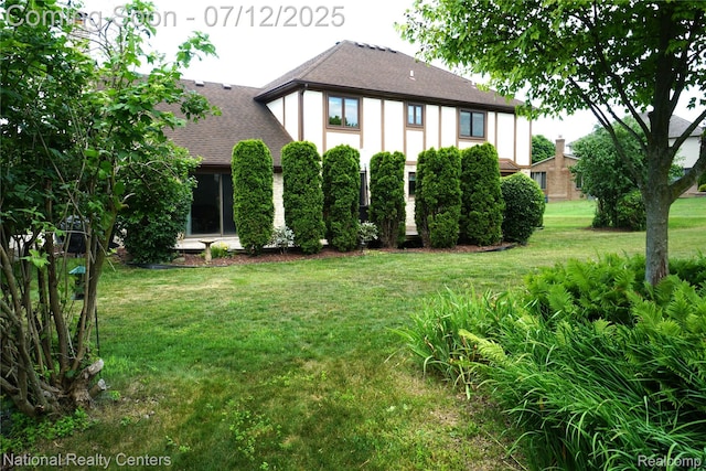 19230 Augusta Ct, Livonia, MI 48152 - back of house with a shingled roof and a lawn