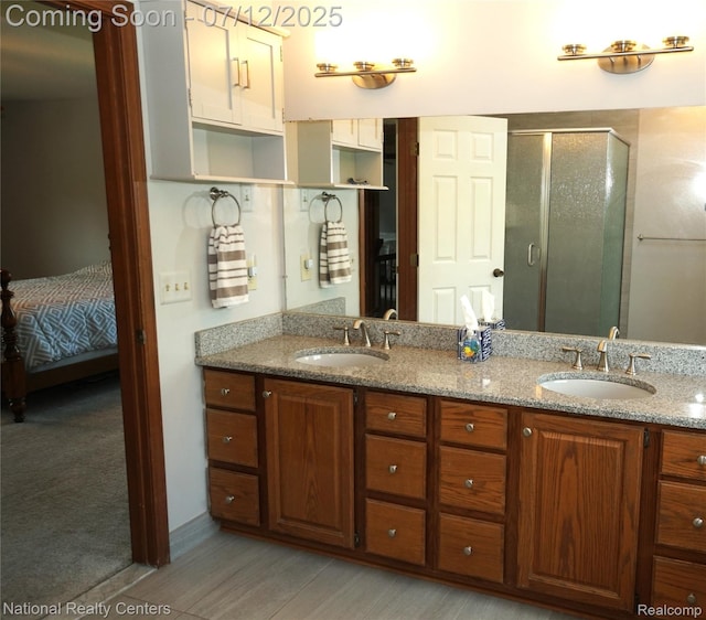 19230 Augusta Ct, Livonia, MI 48152 - bathroom featuring double vanity, a shower stall, connected bathroom, and wood finished floors