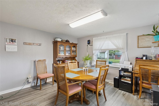 204 W Caroline St, Bellevue, MI 49021 - dining area featuring light wood finished floors and a textured ceiling