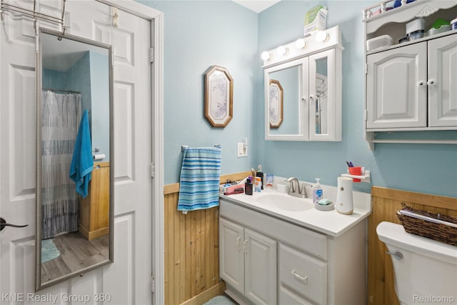 204 W Caroline St, Bellevue, MI 49021 - full bathroom with vanity, a wainscoted wall, wooden walls, and curtained shower