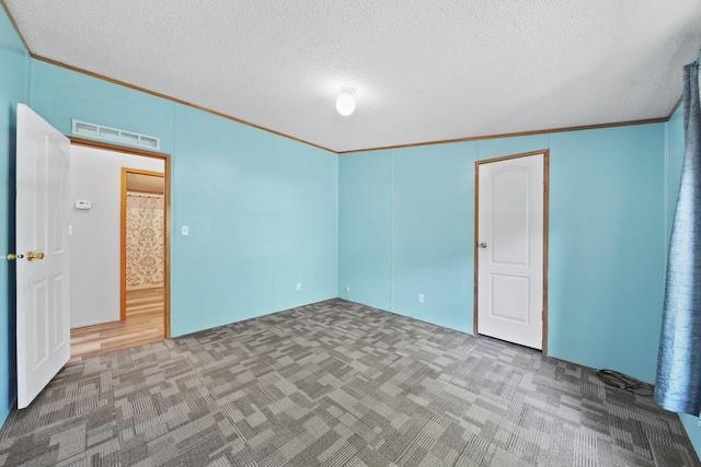 8756 Portage Lake Rd, Munith, MI 49259 - unfurnished bedroom with carpet, crown molding, and a textured ceiling