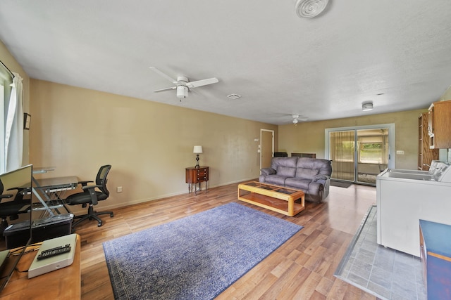 8756 Portage Lake Rd, Munith, MI 49259 - living room with ceiling fan, light wood-style flooring, and washer and clothes dryer