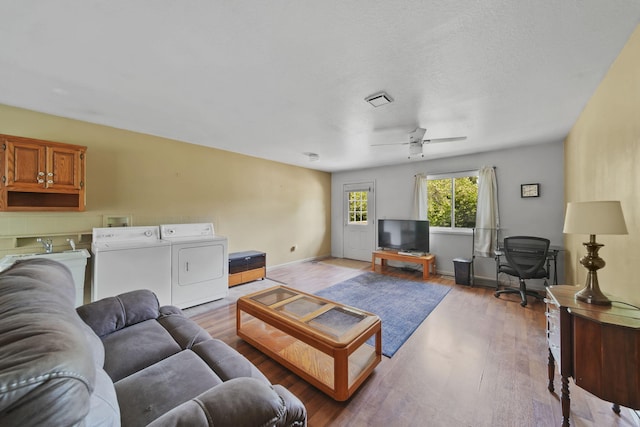 8756 Portage Lake Rd, Munith, MI 49259 - living room featuring washing machine and clothes dryer, wood finished floors, and a ceiling fan