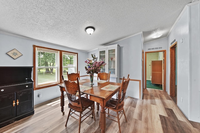8756 Portage Lake Rd, Munith, MI 49259 - dining room with light wood finished floors, ornamental molding, and a textured ceiling
