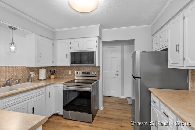 1060 Village Ln, Jenison, MI 49428 - kitchen featuring appliances with stainless steel finishes, white cabinets, backsplash, light wood finished floors, and ornamental molding